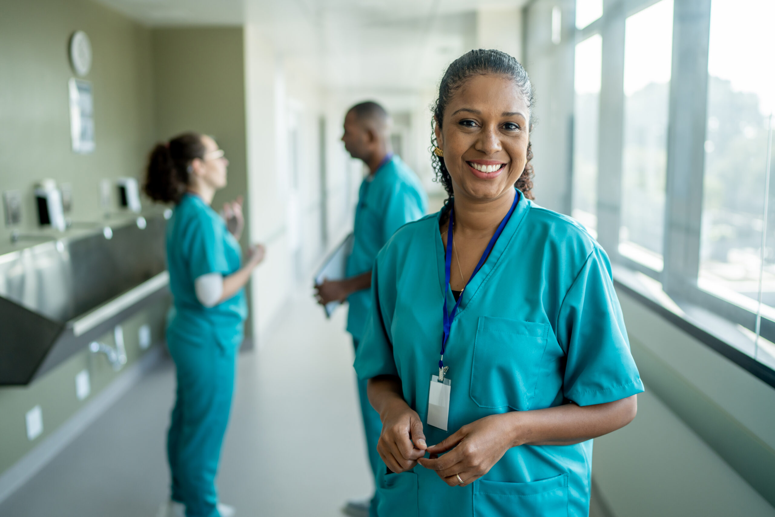 A nurse practitioner consults with a patient while holding a tablet.
